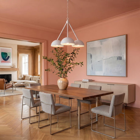 A contemporary dining room with peach walls featuring the Veda 3 Light Chandelier 26 inch in textured white over a walnut table and herringbone floors.