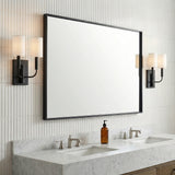Matte Black linear Wall Sconce in a Transitional Bathroom with a white marble double vanity and ribbed wall tiles.