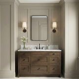 Andrew Wall Sconce 12", Aged Iron geometric Wall Sconce in a Transitional Bathroom with a wood vanity and marble top.