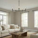 Emrys 5 Light Chandelier 36", Aged Iron linear Chandelier in a Transitional Living Room with a rustic wood coffee table & natural fiber rug.