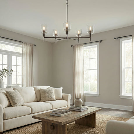 Emrys 5 Light Chandelier 36", Aged Iron linear Chandelier in a Transitional Living Room with a rustic wood coffee table & natural fiber rug.