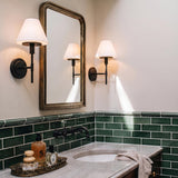 A transitional bathroom featuring the Dean Wall Sconce 14", Matte Black and Opal Glass flanking a rectangular mirror above green subway tile and a marble vanity.