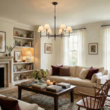 Bryson 6 Light Chandelier 36", Aged Iron linear chandelier in a Transitional Living Room with a cream sofa and dark wood coffee table.