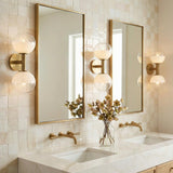 Merrick 2 Light Wall Sconce 15", Modern Brass in a Modern Bathroom with tiled walls and marble countertops.