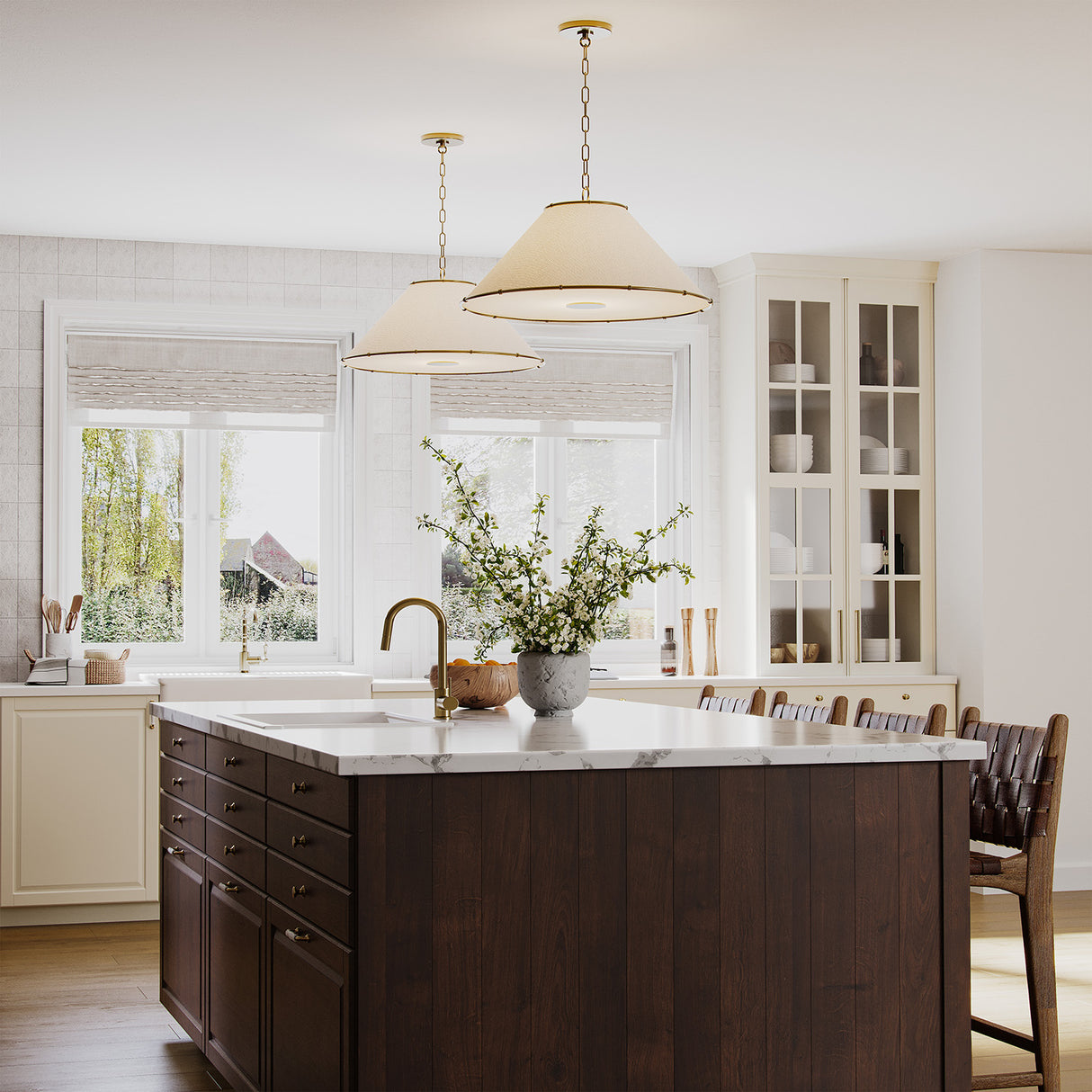 Two Gael Large 28" Pendants, with Gilded Brass detailing, shown in a large kitchen above a dark wood island with marble countertops.