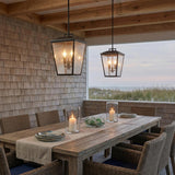 Harrison Outdoor Hanging Light, Old Bronze geometric Outdoor Hanging in a Coastal Outdoor with a rustic wood table and wicker chairs.