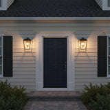 Harrison Outdoor Large Wall Light 16, Textured Black - Two outdoor lanterns flanking a dark blue door with white trim, illuminated at dusk.