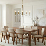 Brass and Clear linear chandelier in a Transitional Dining Room with a wooden dining table and chairs.