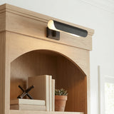 Denton Picture Light 13", Aged Iron linear wall sconce in a Transitional Living Room with a light oak built-in bookshelf.