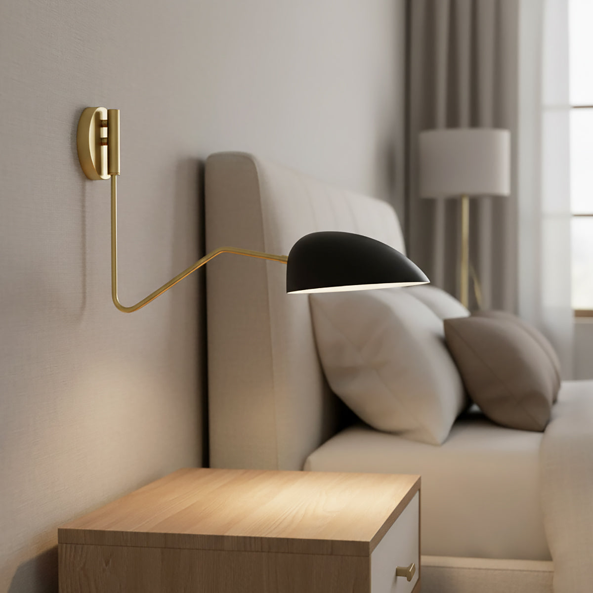 Camden Adjustable Wall Sconce, Matte Black - A matte black wall sconce with a brass arm extends over a bed with neutral bedding and pillows.