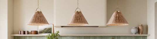 Three rattan Paloma pendant lights hanging above a kitchen counter with a neutral color scheme, with green hand-made backsplash tiles.