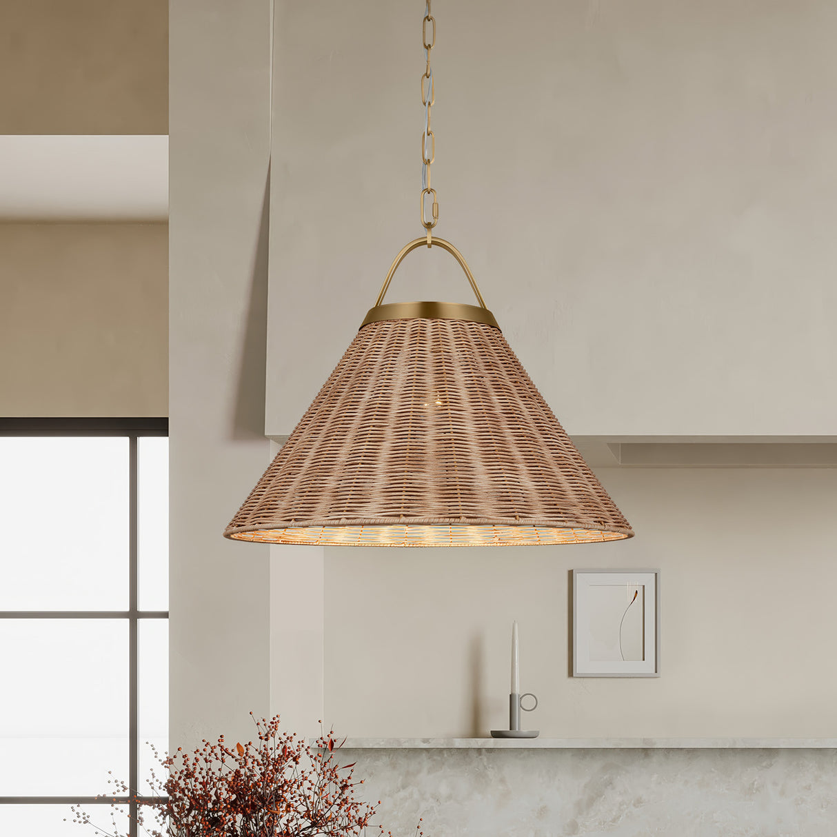 Paloma 22" Pendant light, Modern Brass and Rattan, hung in a kitchen with micro-cement range hood and autumn flowers.
