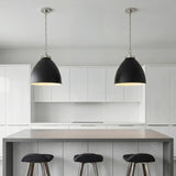 A minimalist kitchen featuring two Rodney Large Pendant 18", Matte Black and Polished Nickel fixtures over a grey waterfall island set against white flat-panel cabinets.