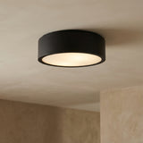 Matte Black geometric flush mount in a Modern Living Room with a minimalist textured wall.