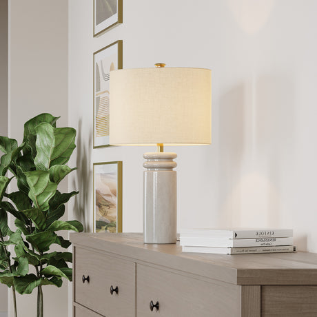 Agnes White lamp on a wooden dresser with books and a plant in a home setting.