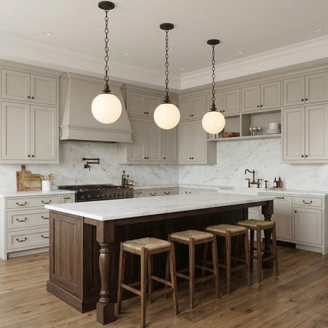 Emerson Medium Pendant 11", Aged Iron globe Pendant in a Transitional Kitchen with a white marble island and woven stools.