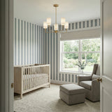 Remington 5 Light Chandelier 26", Satin Brass in a Modern Bedroom with striped walls and a light rug.