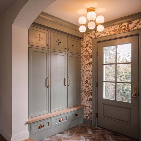 A transitional foyer with the Matilda Semi-Flush 20 inch Modern Brass and Milk Glass fixture on the ceiling above sage green cabinets and herringbone brick floors.