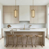 Robin 4 Light LED Pendant 16", Modern Brass geometric Pendant in a Modern Kitchen with a white marble island and wood stools.