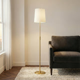 Petra Floor Lamp 65", Modern Brass geometric Floor Lamp in a Modern Living Room with a dark velvet sofa and shag rug.