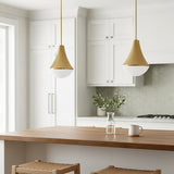 A transitional kitchen features two Skylar Pendant 11", Satin Brass pendants in satin brass and frosted glass over a wood island with white cabinets and hexagon tile backsplash.