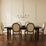 Wyatt 4 Light Chandelier 25 - A modern dining room with a brass chandelier over a dark wood table surrounded by upholstered chairs.