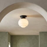 Irving Small Flush Mount 9", Black geometric flush mount in a Modern Entryway with a stucco archway and muted green walls.