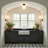 A transitional kitchen features an Irving Medium Flush Mount 12", Black with frosted glass along an arched ceiling over a farmhouse sink and charcoal cabinets.