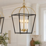 A transitional kitchen features a Langford Large Lantern Pendant in black and satin brass over an island with white cabinetry and a marble backsplash.
