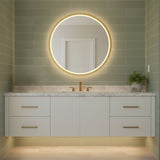 Norma Large LED Round Mirror 42" x 42", Brushed Brass - Round LED mirror illuminating a bathroom with green tile walls and a white vanity.