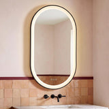 A contemporary bathroom with the Sherman Large LED Oval Mirror 24" x 42", Brushed Black mounted above a white marble vanity and matte black faucet against terracotta tiles.