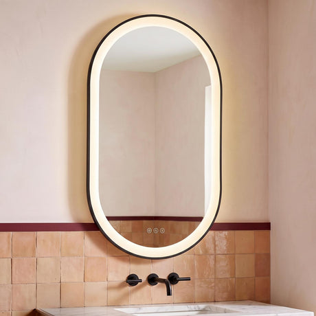A contemporary bathroom with the Sherman Large LED Oval Mirror 24" x 42", Brushed Black mounted above a white marble vanity and matte black faucet against terracotta tiles.