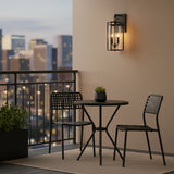 Peyton Outdoor Wall Light, Medium 18" Textured Black - Wall light illuminating a balcony with table and chairs.