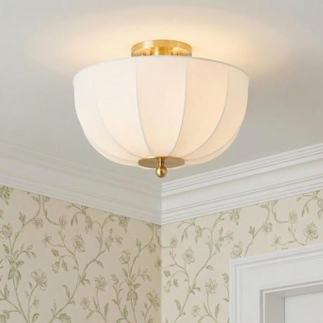 Mayfair Aged Brass scalloped fabric Flush Mount in a Traditional Bedroom with floral wallpaper and white crown molding.