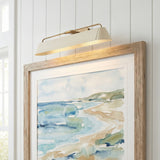 Henley Picture Light 25", Patina Brass and Soft Sand linear wall sconce in a Coastal Living Room with rustic oak framed art.