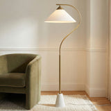 Seraphina Floor Lamp, Aged Brass geometric Floor Lamp in a Transitional Living Room with a green velvet armchair and textured rug.