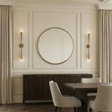 Camellia 2 Light Wall Sconce 34", Patina Brass linear design Wall Sconce in a Transitional Dining Room with a dark fluted sideboard.