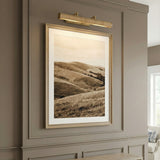 Judy Large Picture Light 24", Aged Brass and Grasscloth woven picture light in a Transitional Living Room with wainscoting and framed art.