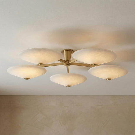 Imogen LED 5 Light Flush Mount 60", Vintage Brass and Opal Glass Vintage Brass geometric flush mount in a Modern Living Room with textured walls.