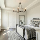 Tamsin 6 Light Chandelier 40, Forged Iron geometric Chandelier in a Modern Farmhouse Bedroom with an iron bed and patterned rug.