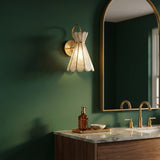 Winifred Wall Sconce 12", Aged Brass scalloped Wall Sconce in a Transitional Bathroom with a green wall and marble vanity.