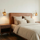 Aged Brass geometric wall sconce in a Mid-Century Bedroom with a leather headboard and walnut nightstand.