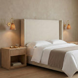 Rhiannon Wall Sconce 16", Aged Brass and pleated Wall Sconce in a Contemporary Bedroom with an upholstered headboard and fluted nightstand.