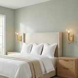 Esther Wall Sconce 14", Aged Brass with Rattan Accents globe wall sconce in a Transitional Bedroom with natural wood nightstands.