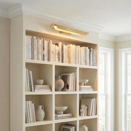 Mitchell LED Picture Light 27", Aged Brass linear Wall Sconce in a Transitional Living Room with built-in bookshelves.
