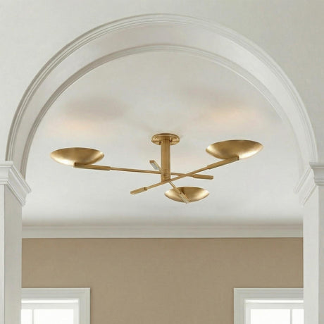 A contemporary entryway featuring the Phoebe aged brass semi-flush mount along the ceiling center framed by a large white archway and beige walls.