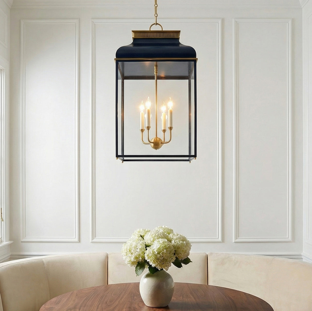 Harriet Lantern Pendant 19", Midnight Blue and Aged Brass geometric pendant in a Transitional Dining Room with a round wooden table and banquette.