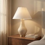 Lucille Table Lamp, Glossy Cream globe Table Lamp in a Transitional Bedroom with a dark wood nightstand.