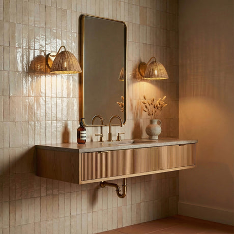 Aged Brass and Woven Wicker woven wall sconce in a Transitional Bathroom with a floating slatted wood vanity and gold framed mirror.