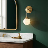 Isabella Wall Sconce 11", Aged Brass with Art Glass globe wall sconce in a Transitional Bathroom with a white marble vanity.